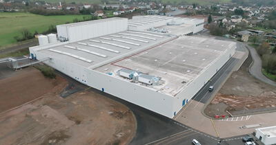 Weiße Logistikhalle mit Oberlichtern am Dorfrand von oben