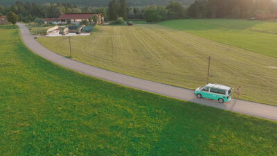 Drohnenaufnahme eines Campervans auf einer Landstraße zwischen Feldern Drohnenaufnahme eines Campervans auf einer Landstraße zwischen Feldern, Luftaufnahme, Vogelperspektive und Landschaft als 4K