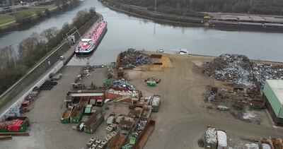 Schrottplatz am Kanal mit Tankschiff und Mulden von oben