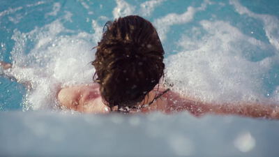 Person entspannt im sprudelnden Whirlpool von hinten gesehen