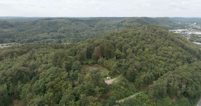 Drohnenflug über bewaldete Hügel mit Autobahn im Tal