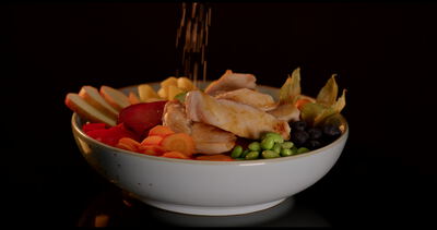 Bunte gesunde Bowl mit Edamame roter Bete und Physalis vor schwarzem Hintergrund