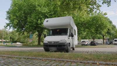 Wohnmobil steht mit der Front voran an einer Grünfläche im Park: Wohnmobil Frontansicht, Reisemobil von vorne