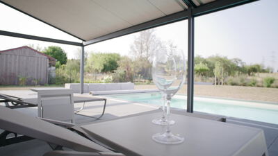 Moderne Terrasse mit Pool und zwei Weingläsern am Haus