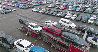 Autotransporter beladen mit Neuwagen auf einem Fahrzeugterminal