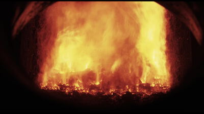 Lodernde Flammen füllen die Brennkammer einer Biomasse Verbrennung