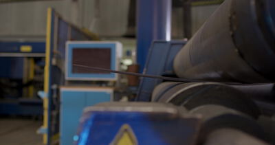 Verseilmaschine mit Steuerungsmonitor bei der Stahlseilproduktion
