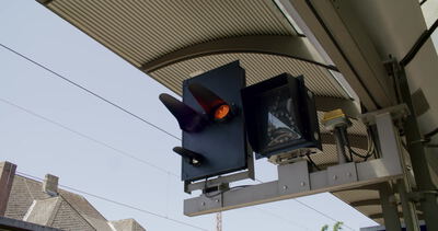 Bahnsignal mit leuchtendem Licht am Bahnsteig in Nahaufnahme