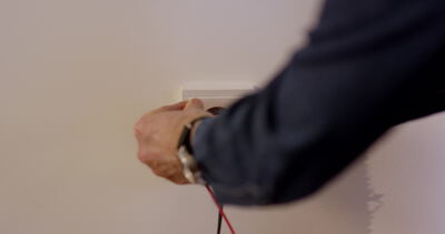Elektriker installiert Steckdose an einer Wand im Innenraum Elektriker installiert Steckdose an einer Wand im Innenraum, Steckdose installieren Video, Elektriker bei der Arbeit und