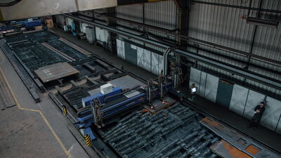 Große CNC Brennschneidanlage in einer Werkhalle von oben gesehen Große CNC Brennschneidanlage in einer Werkhalle von oben gesehen, CNC Schneidanlage, Schneidtisch und Stahlverarbeitung als