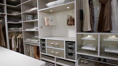 Begehbarer Kleiderschrank mit Regalen und hängender Kleidung