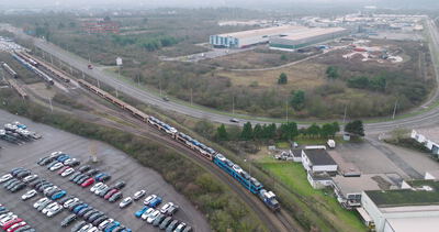 Luftaufnahme über Fahrzeuglager und Güterbahn aus der Drohne