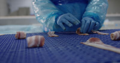 Baconröllchen werden in der Fleischfabrik von Hand gerollt