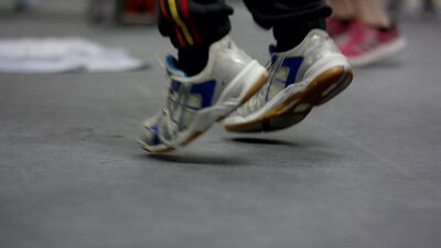 Nahaufnahme von Sportschuhen bei schneller Fußarbeit in der Sporthalle