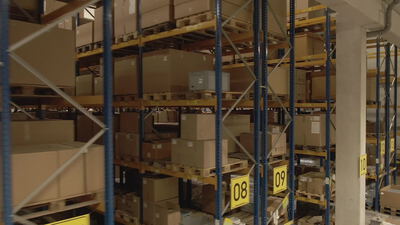 Fahrt durch ein Hochregallager mit Paletten und Kartons in der Logistik