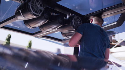 Arbeiter montiert runde Marine Lautsprecher unter dem Hardtop eines Bootes