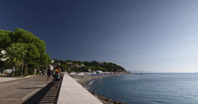 Passanten spazieren auf der Strandpromenade an der Bucht Passanten spazieren auf der Strandpromenade an der Bucht, Promenade am Meer, Spaziergang am Meer und Uferpromenade als 4K