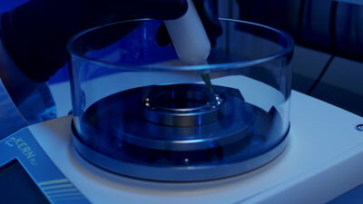 Laborwaage mit Glaskammer beim Einwiegen einer kleinen Probe
