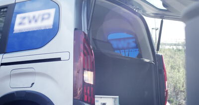 Servicetechniker entnehmen Ausrüstung aus einem weißen Einsatzfahrzeug