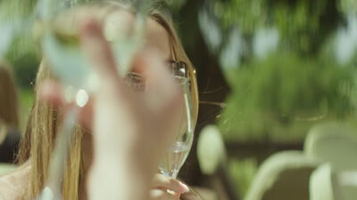 Junge Frau genießt ein Glas Weißwein in der Nachmittagssonne