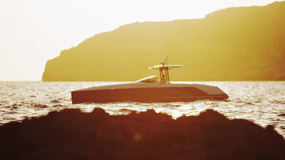 Motoryacht als Silhouette gleitet zur goldenen Stunde an der Küste