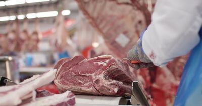 Metzger zerlegt Rindfleisch am Zerlegetisch der Fleischindustrie