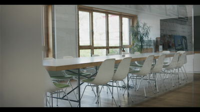 Langer weißer Konferenztisch mit Stühlen im hellen Besprechungsraum