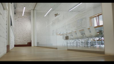 Leerer Boardroom mit Ziegelwand und Holzboden hinter Glas