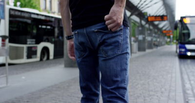 Mann greift an einer Bushaltestelle in die Gesäßtasche, Mann an Bushaltestelle, Pendler Bushaltestelle Video und Mann greift