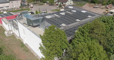Solardach auf Industriegebäude in schräger Luftaufnahme von oben
