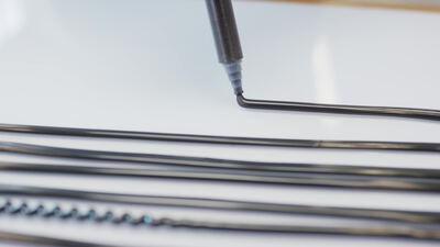 Makroaufnahme eines gebogenen Heizelements aus Metall auf glänzender Fläche