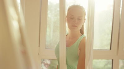 Frau streckt ihre Arme am sonnigen Fenster im Gegenlicht Frau streckt ihre Arme am sonnigen Fenster im Gegenlicht, Frau am Fenster, Dehnübung und Dehnen als 4K Stockvideo
