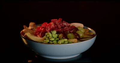 Gesunde Bowl mit grünen Weintrauben Kirschtomaten und Edamame vor dunklem Hintergrund