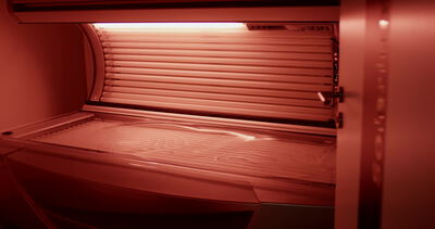 Leere Sonnenbank mit roten Bräunungsröhren im Solarium
