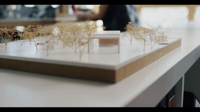 Architekturmodell eines Glaspavillons zwischen Miniaturbäumen