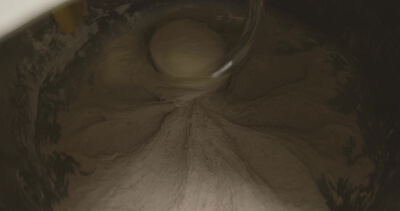 Nahaufnahme von Teig der in einer Schüssel geknetet wird