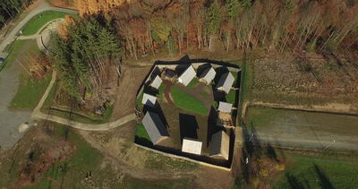 Drohnenflug über ringförmigen Gebäudekomplex mit Gartenhof