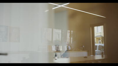 Atmosphärischer Büroinnenraum mit Person am sonnigen Fenster