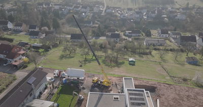 Luftaufnahme eines Wohngebiets mit Kran auf einer Baustelle