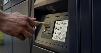 Kontaktloser Türöffner drückt eine Taste am Paketautomaten Kontaktloser Türöffner drückt eine Taste am Paketautomaten, kontaktloser Türöffner Paketautomat, Taste drücken ohne