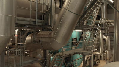 Große isolierte Kanäle verlaufen diagonal durch die Industriehalle
