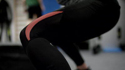 Beine in Leggings bei Kniebeugen im Fitnessstudio