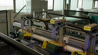 Automatisiertes Handhabungssystem bewegt Folienrolle in der Fabrik Automatisiertes Handhabungssystem bewegt Folienrolle in der Fabrik, Automatisierung, Folienfabrik und Pneumatikzylinder als