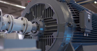 Industrieller Elektromotor mit Antriebswelle in der Fertigungshalle