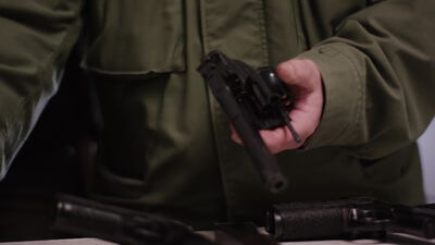 Hand präsentiert einen Revolver über dem Waffentisch Hand präsentiert einen Revolver über dem Waffentisch, Trommel, Revolvertrommel und geladener Revolver als 4K Stockvideo
