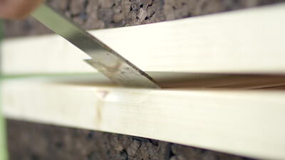 Metallklinge hebelt zwischen zwei Holzleisten der Beute