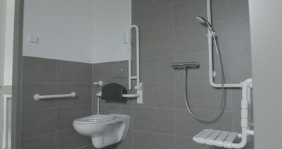 Barrierefreies Badezimmer mit Haltegriffen und Duschklappsitz