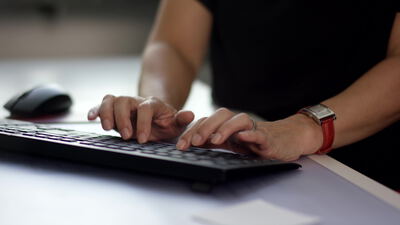 Hände tippen auf einer Computertastatur am Schreibtisch