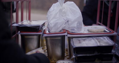 Straßenverkäufer reicht Essen zum Mitnehmen an einem Marktstand
