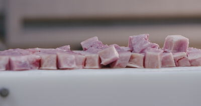 Frische Fleischwürfel liegen auf der weißen Schneidefläche